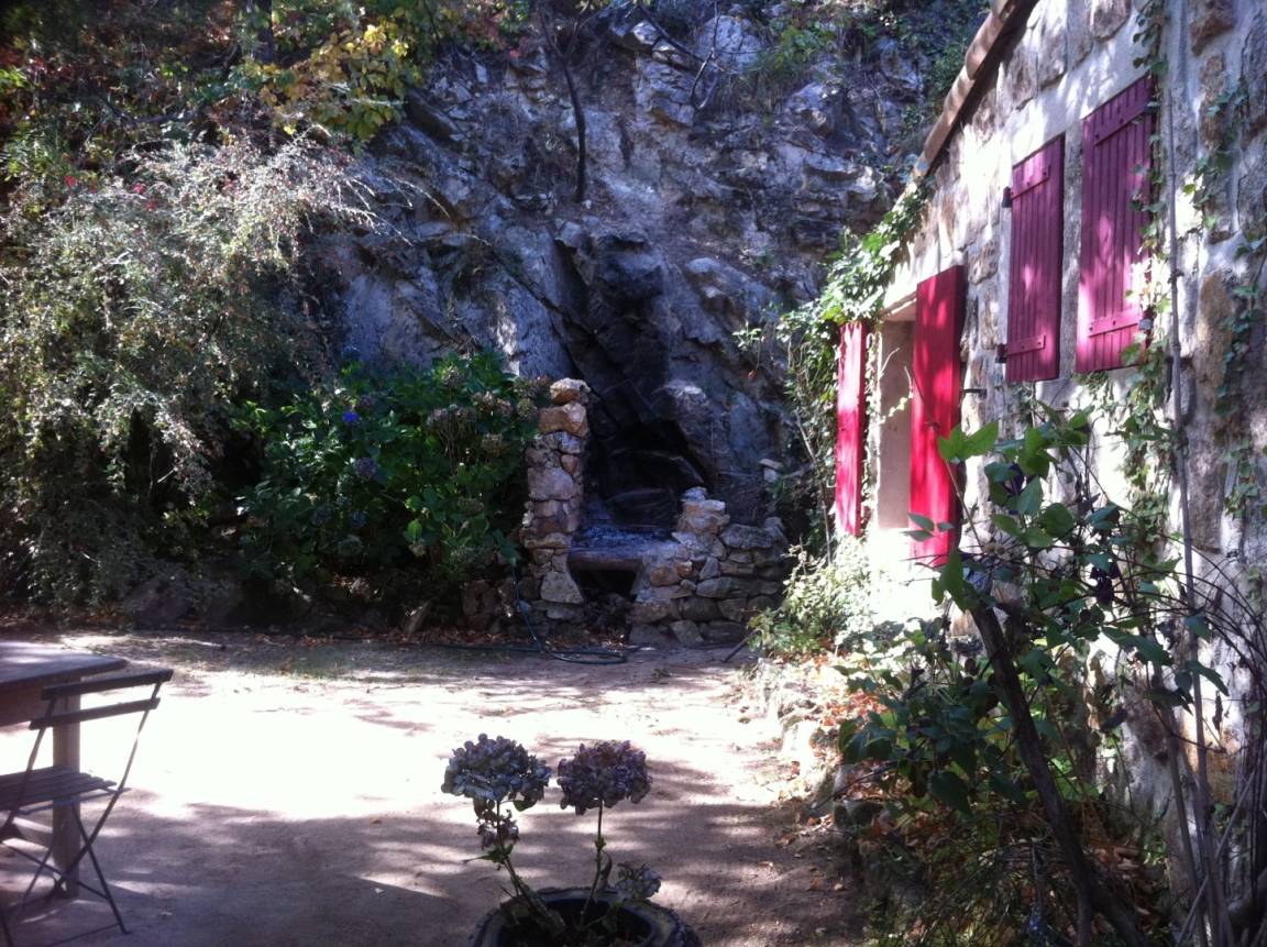 Un barbecue en pierre, taillé à même la roche près de la maison