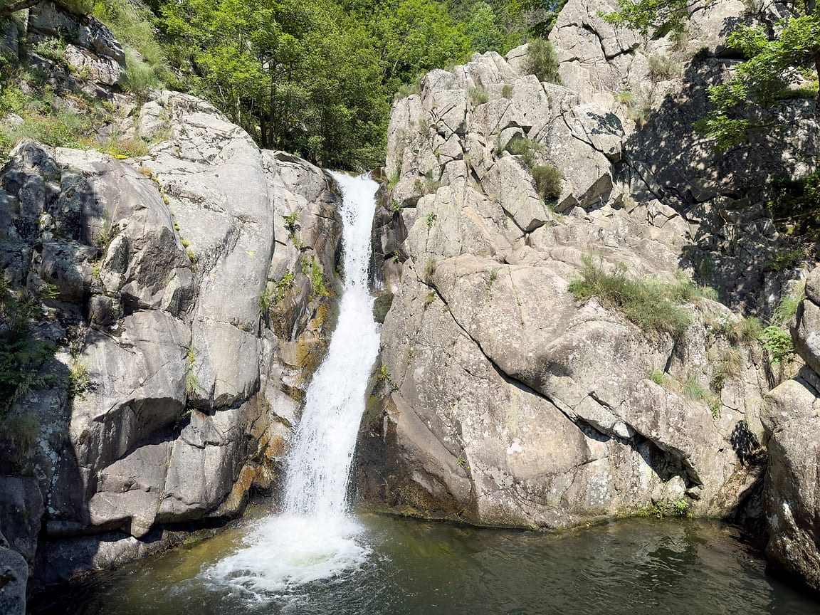 Une petite cascade de la Bésorgues tombant dans une vasque verte, entre des dalles de granite