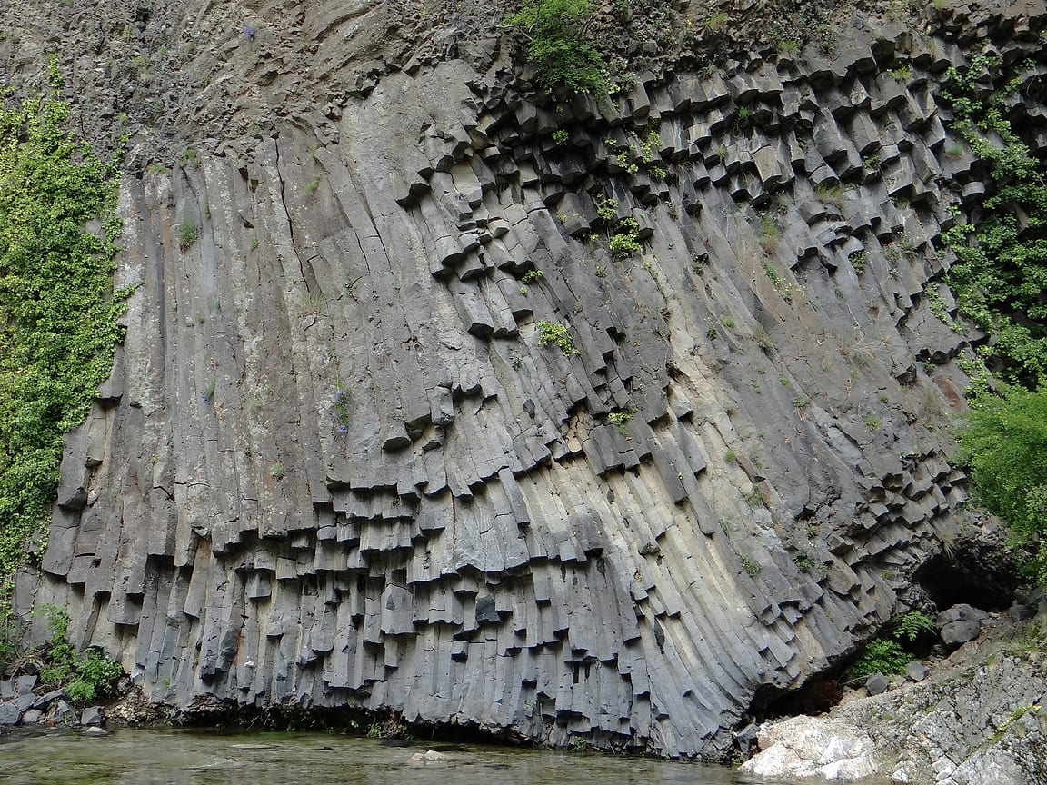 Une paroi de colonnes de basalte prismées au bord du Lignon, à Jaujac