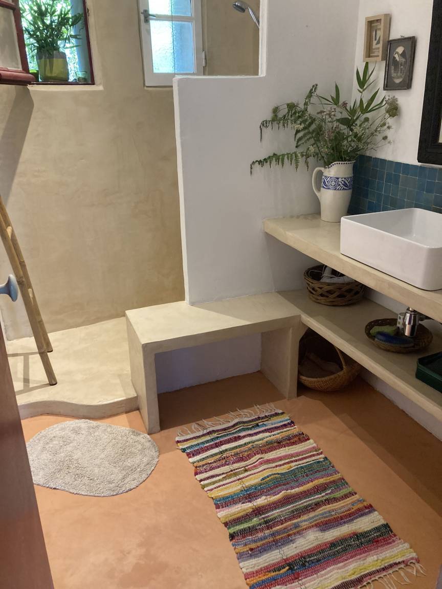 La douche à l'italienne, murs enduits à la chaux, tapis berbère