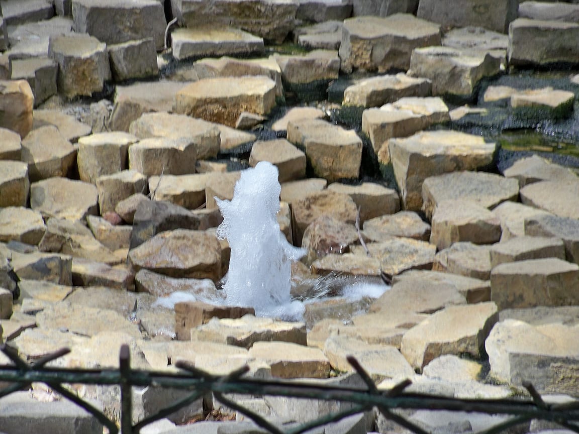 Le jet de la source intermittente de Vals-les-Bains, au milieu de son bassin de pierres